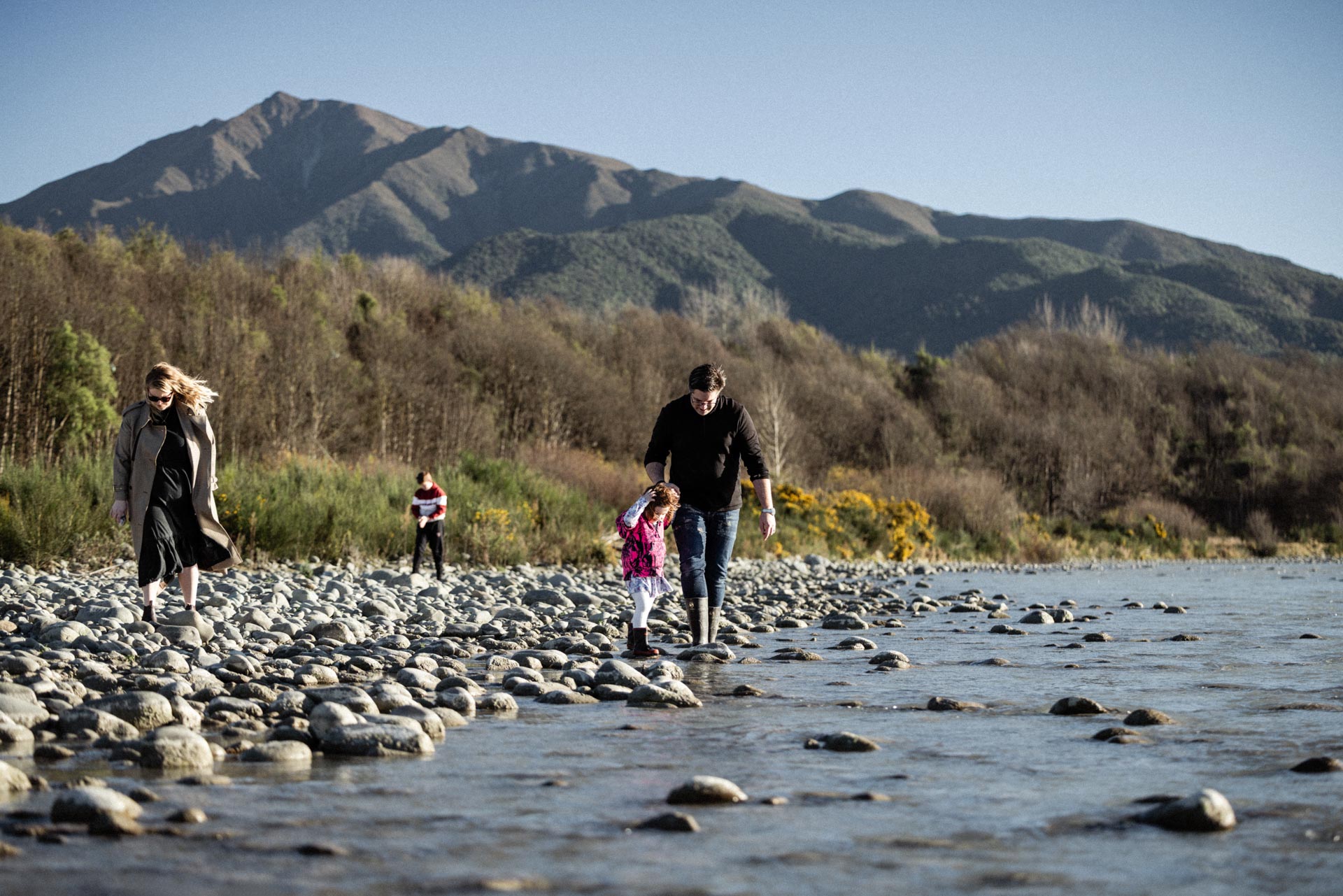 Family walking along the braided Rangitata River with Mt Peel behind
